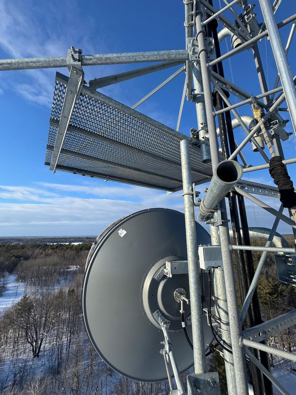 Microwave backhaul dish mounted on a tower at a winter site