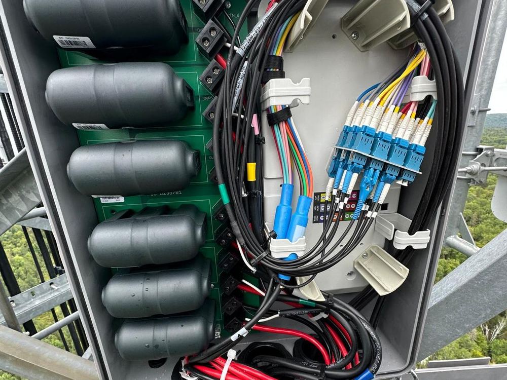 Close-up of fiber and RF cable terminations inside an equipment enclosure