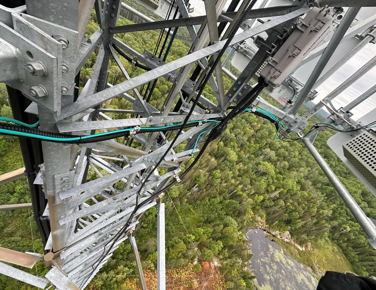 Aerial view down a lattice tower showing cable routing and hardware